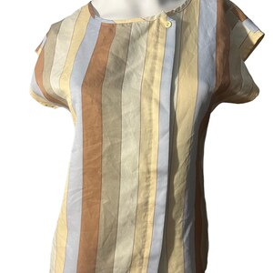 May include: A striped short-sleeved blouse with a button closure. The blouse has vertical stripes in shades of blue, brown, and beige.