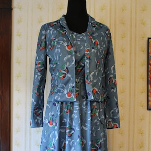 May include: A blue dress with a matching jacket, both featuring a floral pattern in shades of blue, green, red, and white.