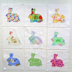May include: Nine fabric bunny rabbit shapes, each with a different pattern. The patterns include polka dots, plaid, floral, and geometric designs. The bunnies are all white with a light blue, pink, green, or yellow background.