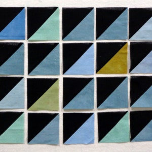 May include: A collection of 18 fabric squares, each with a black triangle on one half and a different color on the other half. The colors include blue, green, yellow, and black.