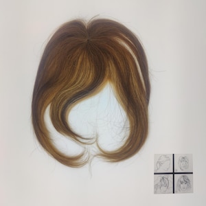 Puede incluir: Una peluca de pelo castaño y rubio con raya lateral. La peluca está diseñada para ser usada como flequillo o flequillo. La peluca se muestra sobre un fondo blanco.