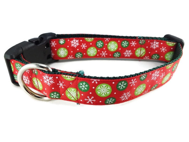 May include: Red dog collar with a green and white snowflake pattern.