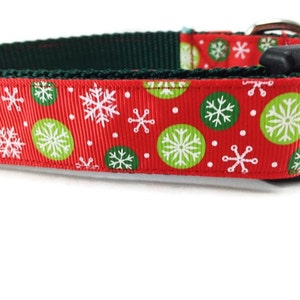 May include: Red dog collar with a green and white snowflake pattern.