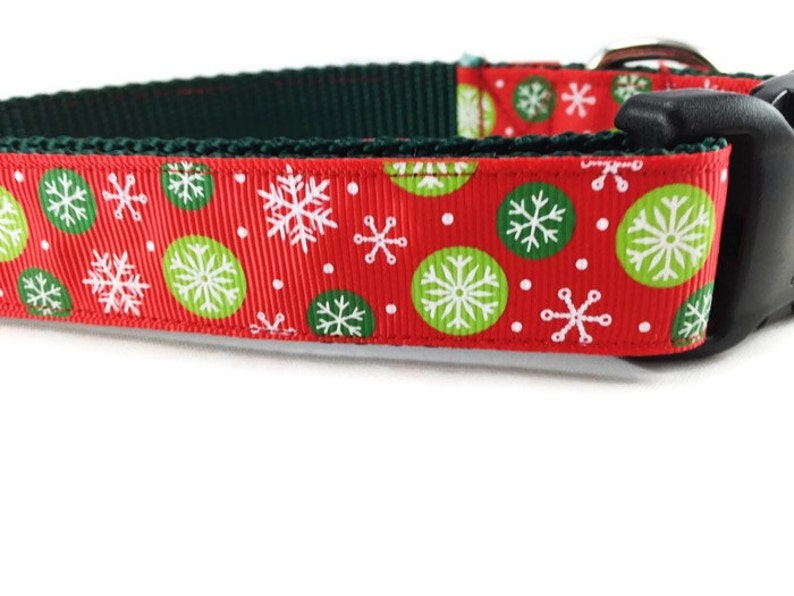 May include: Red dog collar with a green and white snowflake pattern.