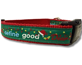 Può includere: Un collare per animali domestici rosso e verde con un motivo festivo di luci natalizie. Il testo "define good" è stampato in bianco, seguito da un piccolo cappello da Babbo Natale rosso e dalla parola "Dear" in corsivo rosso. Fibbia nera.