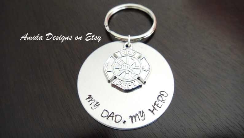 May include: Silver keychain with a firefighter's emblem and the inscription "My Dad. My Hero."