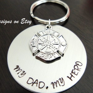 May include: Silver keychain with a firefighter emblem and the words "My Dad. My Hero" engraved on a round tag.
