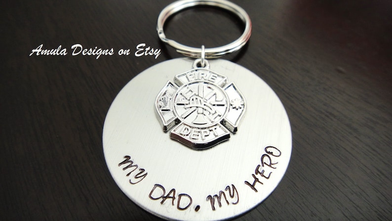 May include: Silver keychain with a firefighter emblem and the words "My Dad. My Hero" engraved on a round tag.