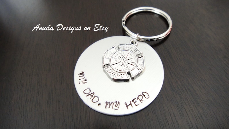 May include: Silver keychain with a round tag that says "My Dad. My Hero." and a silver firefighter emblem charm.