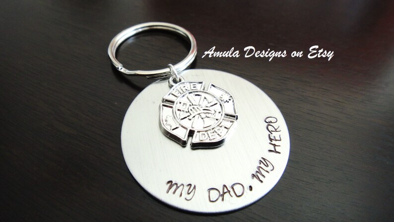 May include: Silver keychain with a firefighter emblem and the words "My Dad. My Hero." engraved on a round tag.