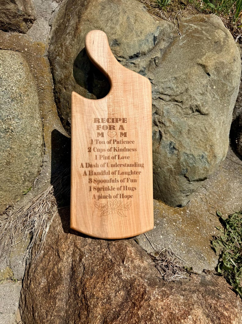 May include: A wooden chopping board with a recipe for a mum engraved on it. The recipe includes ingredients such as patience, kindness, love, understanding, laughter, fun, hugs, and hope.