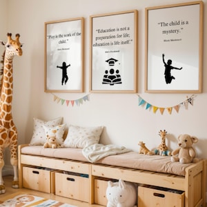 May include: A child's bedroom scene features three framed prints with quotes, a wooden bench with storage, and stuffed animals. The prints display black silhouettes and text. A giraffe toy stands to the left. The bench has a pink cushion and is filled with toys.