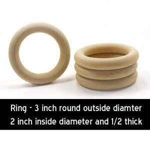 Puede incluir: Dos anillos de madera, uno apilado sobre el otro. El anillo superior tiene un diámetro de 7,6 cm y el anillo inferior tiene un diámetro de 5 cm. Ambos anillos tienen un grosor de 1,2 cm.