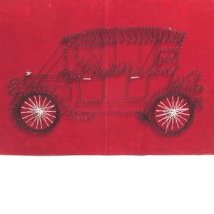 May include: A rectangular wall art piece featuring a string art design of a vintage automobile. The car outline is created with black thread and nails on a vibrant red velvet-like background, with white thread detailing the spoked wheels.