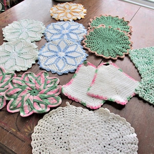 May include: A collection of 10 crocheted doilies in various colors and patterns, including white, green, blue, pink, and yellow. The doilies are made with delicate crochet stitches and feature floral and geometric designs.