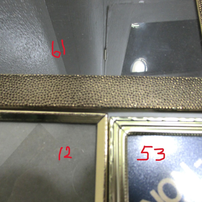 May include: A multi-photo picture frame with a gold-colored beaded border. The frame has multiple openings for displaying photographs. The numbers 61, 12, and 53 are written in red on the frame.