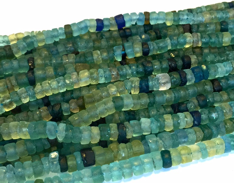 May include: A strand of turquoise, blue, and green glass beads. The beads are irregular in shape and have a rough, textured surface.