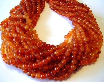 Carnelian shaded round beads full 14" stand.