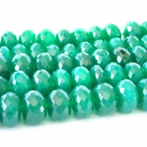 May include: A strand of faceted green agate beads. The beads are round and have a smooth, polished finish.