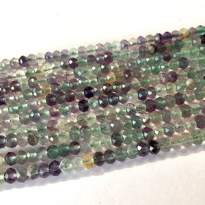 May include: A strand of faceted fluorite beads in shades of green, purple, and clear. The beads are approximately 4mm in size and have a smooth, polished finish.
