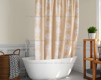 May include: A beige shower curtain with a white floral pattern. The curtain is hanging in a bathroom with a white bathtub and a wooden shelf with a potted plant.