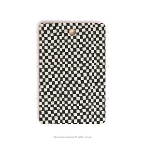 May include: A black and white checkered cutting board with a hole in the top for hanging. The board is made of wood and has a natural finish.