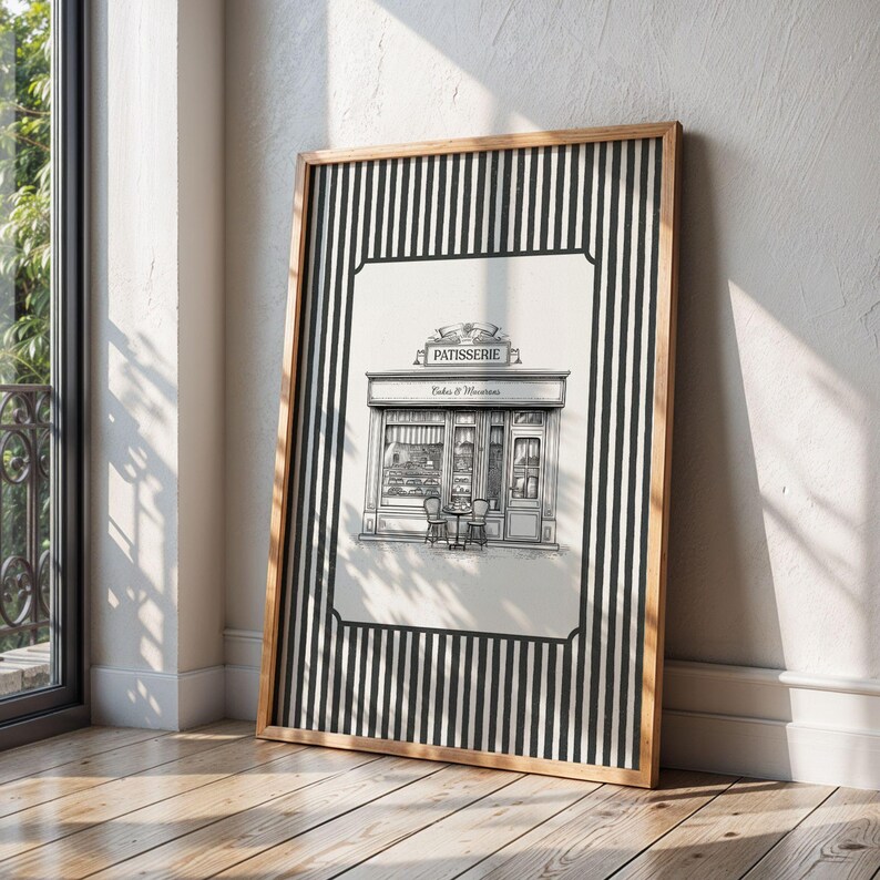 May include: Framed black and white print of a patisserie shop with the word "PATISSERIE" above the entrance. The print is in a wooden frame and has a black and white striped border.