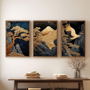 May include: Set of three framed art prints featuring Japanese-inspired landscapes. Each print showcases a different scene: a tree, a mountain, and a crane in flight. The artwork uses gold, blue, and black tones.
