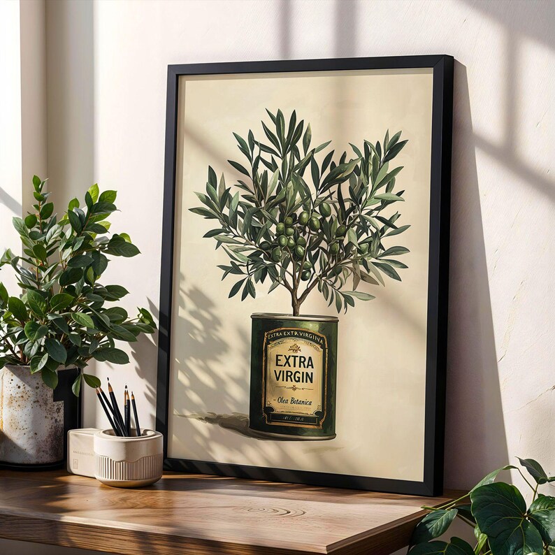 Puede incluir: L&aacute;mina bot&aacute;nica enmarcada que presenta un olivo que crece de una lata de aceite de oliva vintage. La obra de arte muestra ramas y aceitunas verdes sobre un fondo crema. La lata est&aacute; etiquetada como "EXTRA VIRGIN" en letras doradas, con un marco negro.