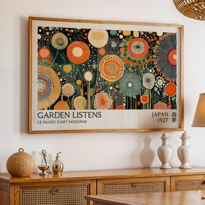 May include: A framed art print featuring a colorful floral design with orange, blue, and yellow circular shapes against a dark background. The print includes the text "GARDEN LISTENS" and "LE MUSÉE D'ART MODERNE" at the bottom, with "JAPAN 1927" on the right.