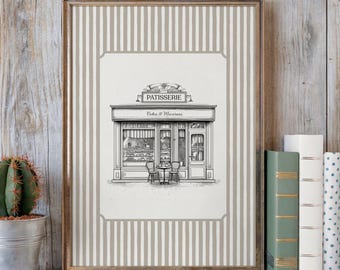 Puede incluir: Impresión enmarcada con una ilustración en blanco y negro de una pastelería, con el texto "PATISSERIE Cakes & Macarons". La impresión tiene un borde a rayas beige y blanco y un marco de madera. Se ve un pequeño cactus en maceta y libros.