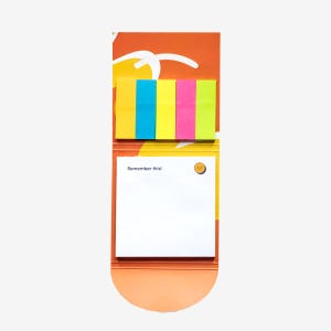 May include: A notepad with a vibrant design. The top section features five sticky notes in yellow, blue, yellow, pink, and green. The bottom section has a white notepad with the text "Remember this!" and a smiling face icon.