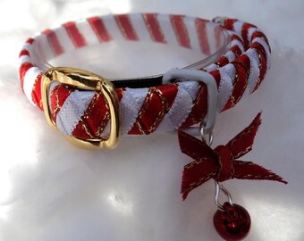 May include: A red and white striped cat collar with a gold buckle and a red bow with a bell charm.