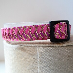 May include: Pink and gold patterned cat collar with a black plastic buckle.