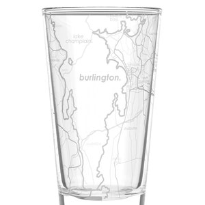 May include: A clear glass with a map of Burlington, Vermont etched on the side. The map includes the text "burlington." and "lake champlain."