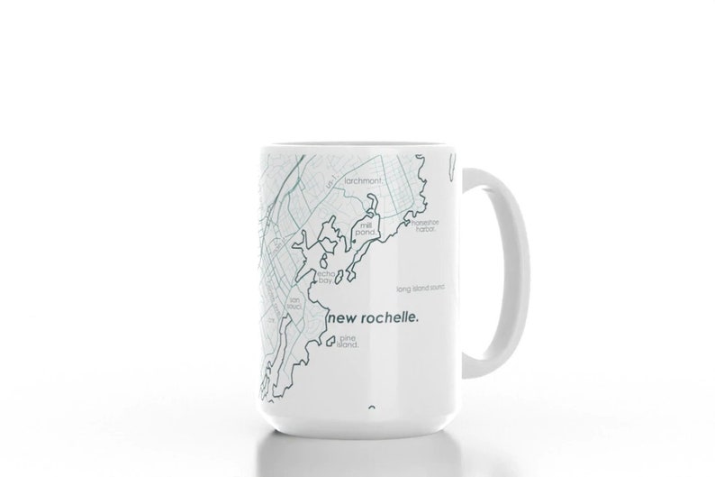 K&ouml;nnte beinhalten: Wei&szlig;e Keramiktasse mit einer Karte von New Rochelle, New York, die darauf gedruckt ist. Die Karte ist in Blaut&ouml;nen und Grau gehalten. Der Text "new rochelle." ist in Grau unter der Karte gedruckt.