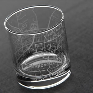 May include: A clear glass tumbler with an etched design of the city of Farmington, New Mexico. The design includes street names and landmarks.