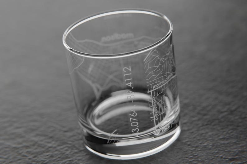 May include: A clear glass tumbler with an etched design of a city map. The map includes street names and coordinates. The coordinates are 3.076 - 82.4112.