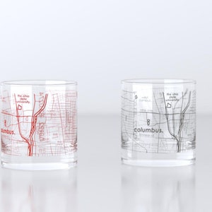 May include: Two clear glass tumblers with a map of Columbus, Ohio printed on them. One tumbler has a red map and the other has a black map. The text "Columbus." is printed on both tumblers.