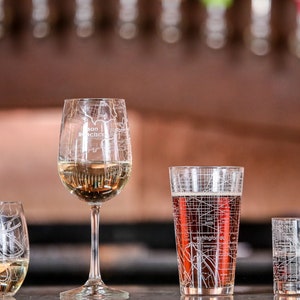 May include: Four glasses with city maps etched on them. The glasses are filled with different beverages. The glasses are arranged in a row on a counter top. The glasses are all different sizes and shapes. The glasses are all clear glass. The glasses are all etched with a city map. The glasses are all filled with different beverages. The glasses are all arranged in a row on a counter top. The glasses are all different sizes and shapes. The glasses are all clear glass.