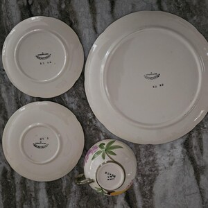 Puede incluir: Juego de cuatro platos vintage de cer&aacute;mica blanca con dise&ntilde;os florales. Los platos tienen un borde elevado y un borde festoneado. Los platos est&aacute;n marcados con las palabras "Made in Japan" y "Hand Painted".