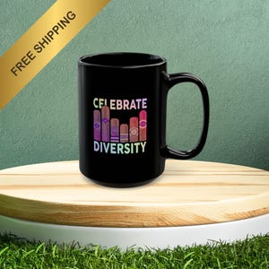 May include: Black ceramic mug with a white graphic that says "Celebrate Diversity" and features a rainbow-colored illustration of five cigars.