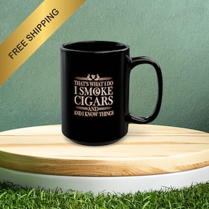 May include: Black ceramic coffee mug with a white design that says "That's what I do I smoke cigars and I know things".