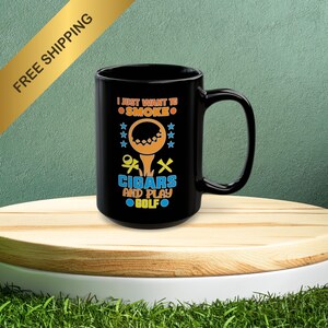 May include: Black coffee mug with a white design that says "I just want to smoke cigars and play golf". The design also includes a golf ball on a tee and a cigar.
