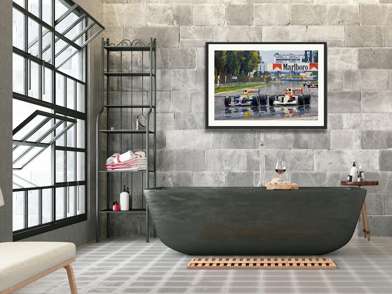 Puede incluir: Una obra de arte enmarcada que representa una carrera de F&oacute;rmula 1 bajo la lluvia, con coches en la pista. La obra cuelga sobre una ba&ntilde;era gris oscuro en un ba&ntilde;o moderno con una ventana grande y una estanter&iacute;a de metal.