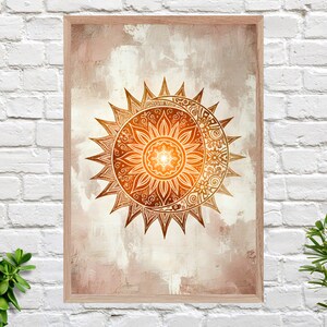 Könnte beinhalten: Gerahmter Wandkunstdruck mit einem Sonnen- und Mond-Design in Orange- und Brauntönen. Das Kunstwerk weist detaillierte Muster auf und ist vor einem strukturierten, neutralen Hintergrund platziert. Der Rahmen besteht aus hellem Holz.