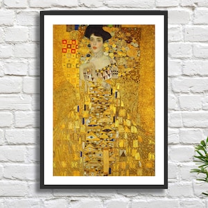 May include: A framed print of a painting depicting a woman in a gold dress with a geometric pattern. The background is a gold mosaic with a floral design.
