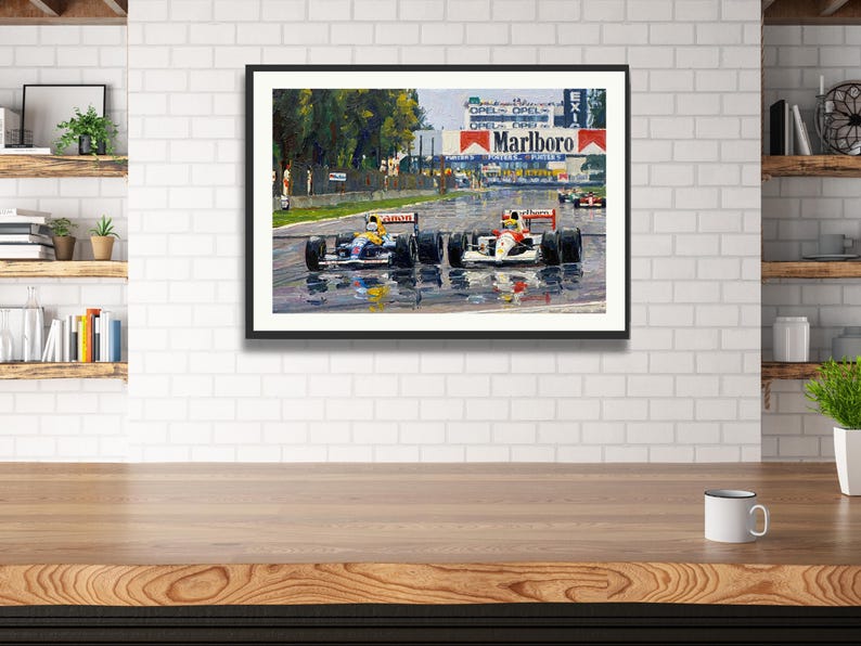 Puede incluir: Obra de arte enmarcada que representa una carrera de F&oacute;rmula 1. Dos coches de carreras est&aacute;n en primer plano, con el logotipo de Marlboro visible en el fondo. La pista est&aacute; mojada, reflejando los coches y el entorno.