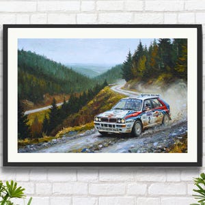 Könnte beinhalten: Gerahmtes Kunstwerk eines Rallyeautos, das eine kurvenreiche Bergstraße entlangfährt. Das Auto ist weiß mit roten und blauen Streifen und dem Schriftzug "MARTINI RACING". Der Hintergrund zeigt einen üppigen grünen Wald und einen bewölkten Himmel.