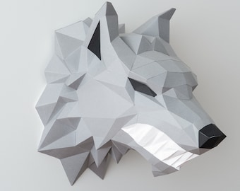 Puede incluir: Una escultura de cabeza de lobo de papel gris con una expresión feroz. La cabeza de lobo está hecha de papel doblado y tiene un efecto tridimensional.